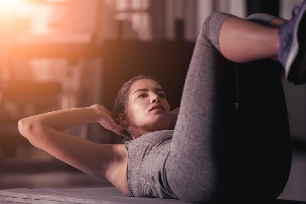 woman has neck pain during ab workouts